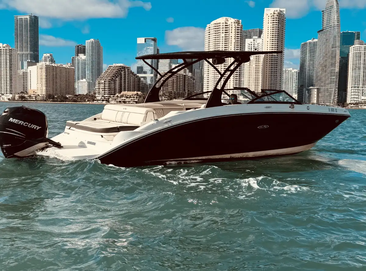 Champagne bottle and glasses on the deck of a 30-foot Sundeck during a private boat tour in Miami at sunset